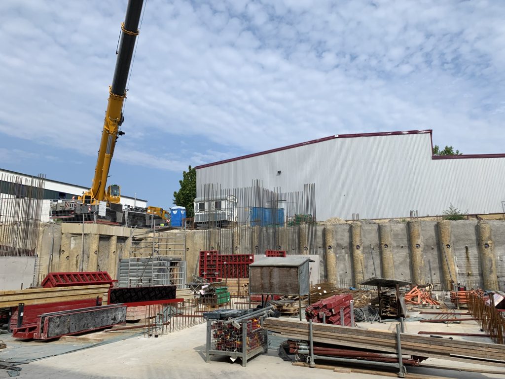 Neue Produktionsfläche im Bau mit Kran und Tiefgarage auf der Baustelle